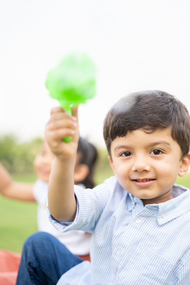 Little Boy Holding a Toy Outdoors